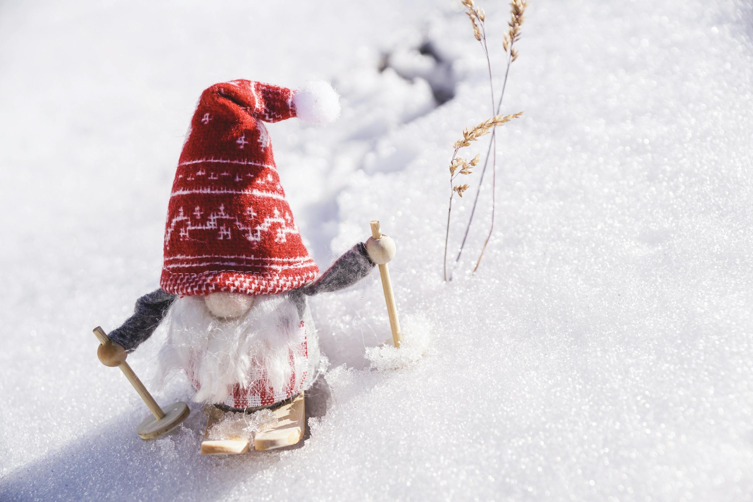 Adorable gnome figurine skiing through fresh snow, capturing the essence of winter fun.