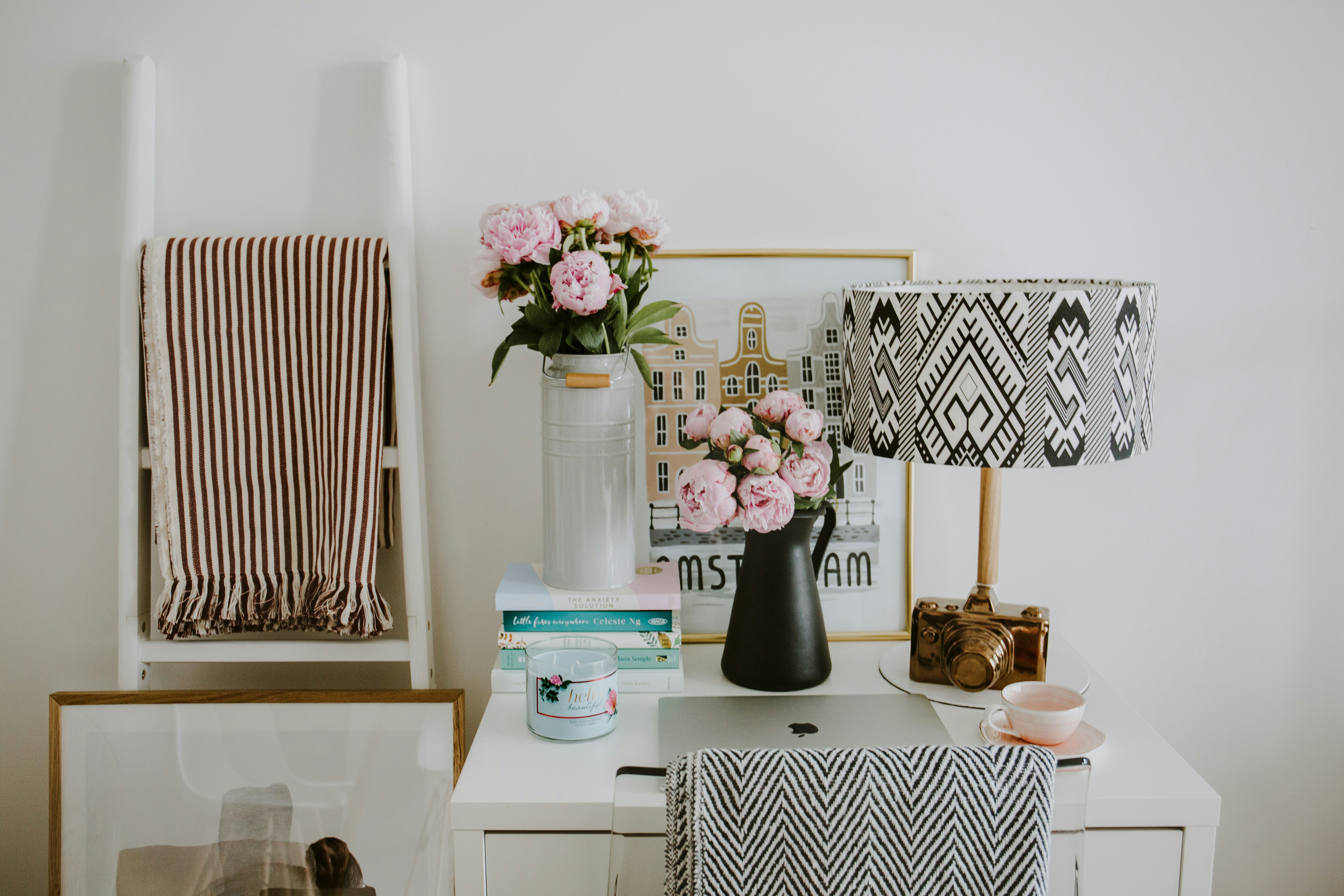 Cosy home office setup with pretty lamp and fresh flowers on desk