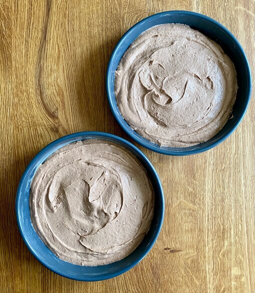 Two cake tins filled with chocolate cake mix