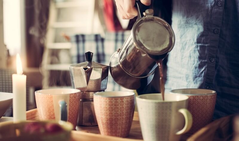 Coffee being poured into mugs