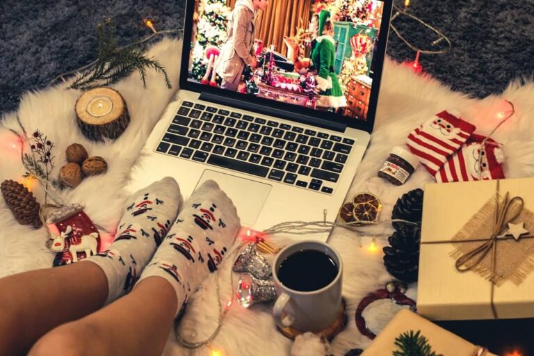Laptop with feet in snowman socks and Christmas ornaments